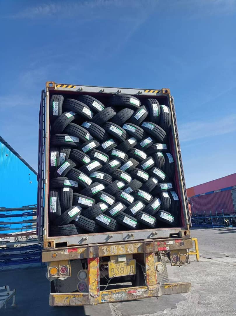 Contenedor lleno de llantas AT   listas para distribución, apiladas de forma eficiente.